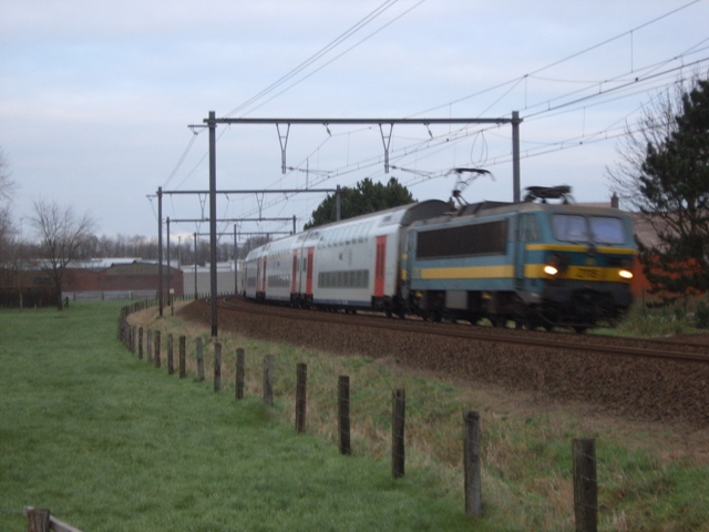 De 27xx onder een dreigende hemel met een IC-trein Oostende - Kortrijk in de bocht van Loppem.