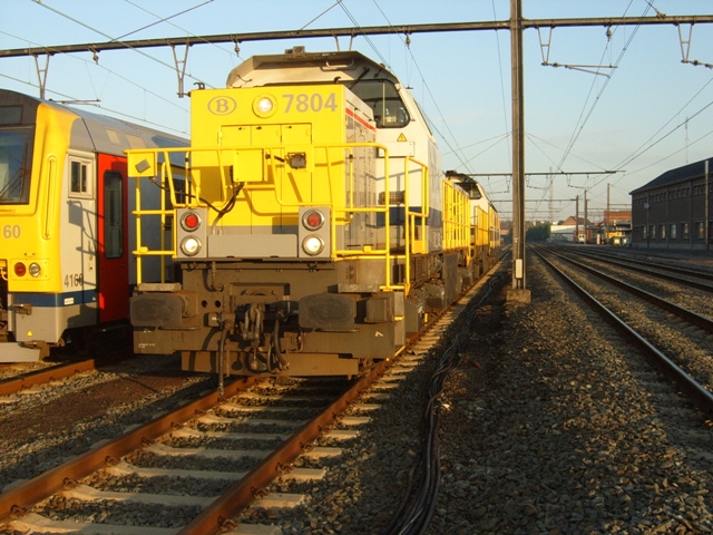 De 7804 staat vol ongeduld te wachten in de bundels van Merelbeke. Achter de loc hangen nog de 7716 en de 6306.