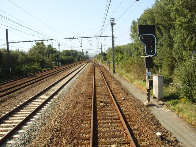 Om een wissel te kunnen nemen om richting spoor 3 te kunnen sporen om om te lopen, moest er praktisch tot in Liedekerke gereden worden. Hier pinkt het inrijsein van Denderleeuw al rood-wit.